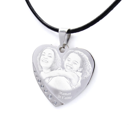 Pendentif cœur gravé avec une maman et sa fille. Message “Maman je t’aime” et finition strass pour un cadeau émouvant.