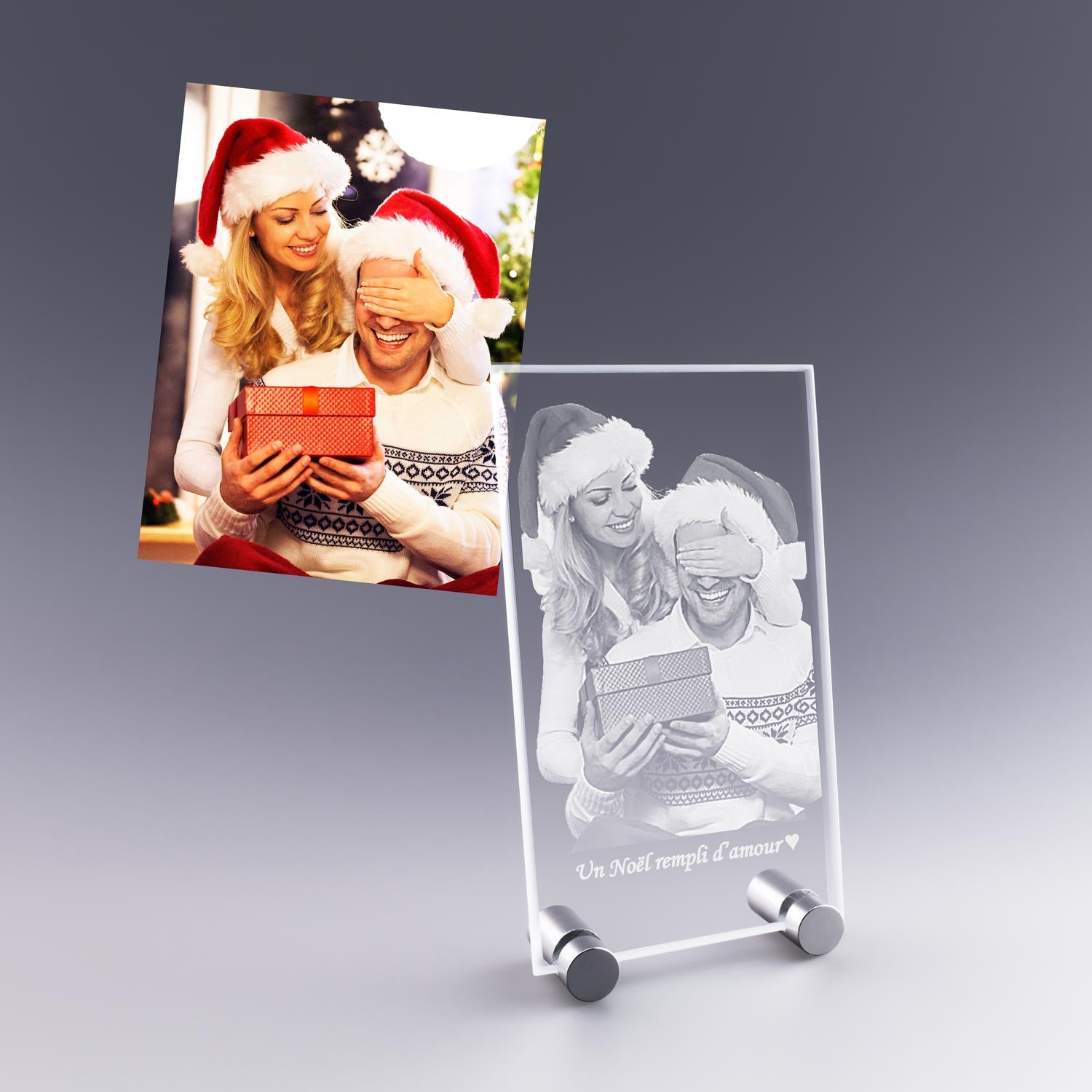 Cadeau de Noël personnalisé : plaque photo en verre verticale gravée en 2D avec un couple en bonnet de Noël, tenant un cadeau.
