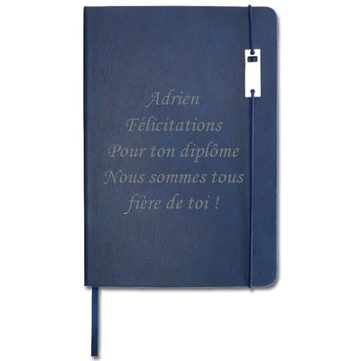 Carnet A5 bleu à couverture rigide personnalisée avec gravure “Adrien Félicitations pour ton diplôme, nous sommes tous fiers de toi !”.