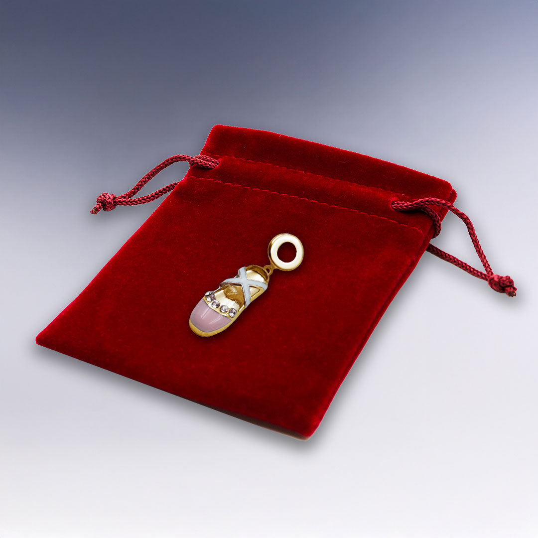 Charm doré en forme de chausson de danse avec strass brillants, livré sur une pochette velours rouge. Une touche féminine et élégante pour votre bracelet.