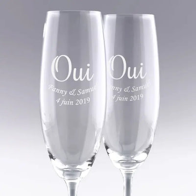 Duo de flûtes à champagne gravées "OUI" avec prénoms et date. Cadeau de mariage personnalisé parfait pour célébrer l’union des mariés avec élégance.