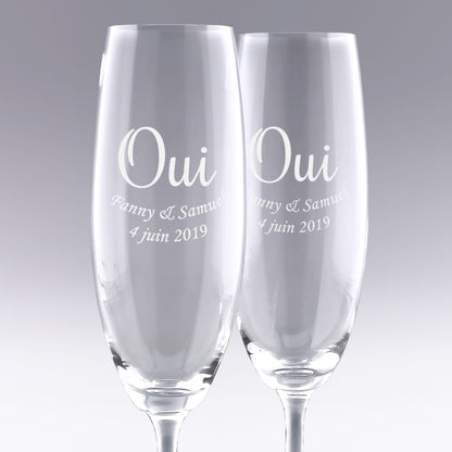 Duo de flûtes à champagne gravées "OUI" avec prénoms et date. Cadeau de mariage personnalisé parfait pour célébrer l’union des mariés avec élégance.