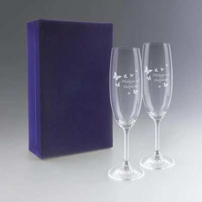Coffret cadeau contenant deux flûtes à champagne personnalisées avec des prénoms et gravure de papillons. Un cadeau raffiné pour couple ou mariage.