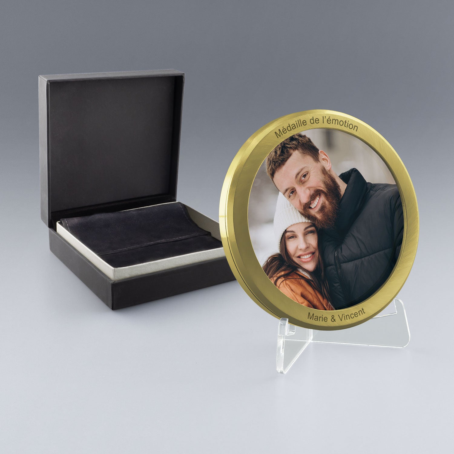 Médaille dorée personnalisée avec une photo couleur d’un couple et gravure des prénoms, présentée dans un coffret noir élégant.