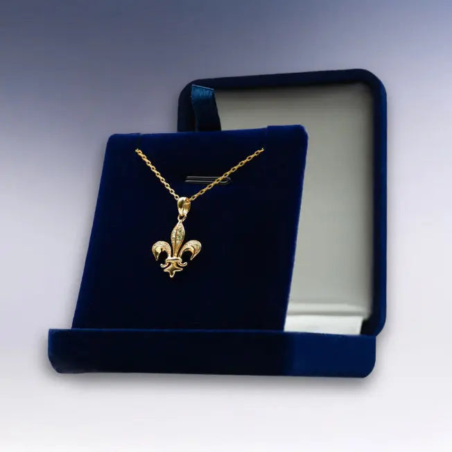 Collier doré Fleur de Lys, symbole de royauté, livré dans un écrin bleu personnalisable. Parfait pour une attention distinguée.
