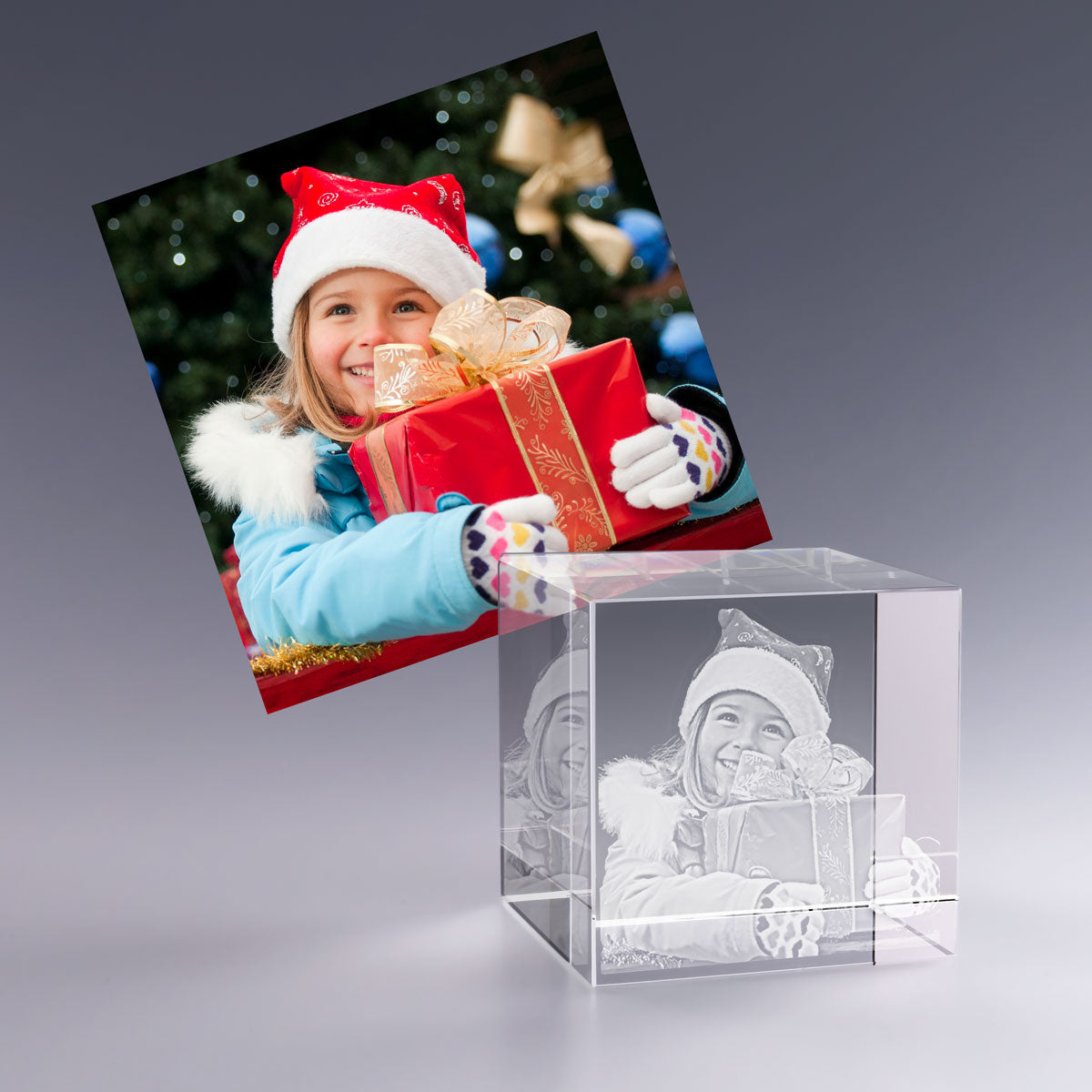 Bloc en verre personnalisé 6 cm avec gravure laser d'une enfant tenant un cadeau de Noël. Souvenir magique à offrir pour les fêtes.