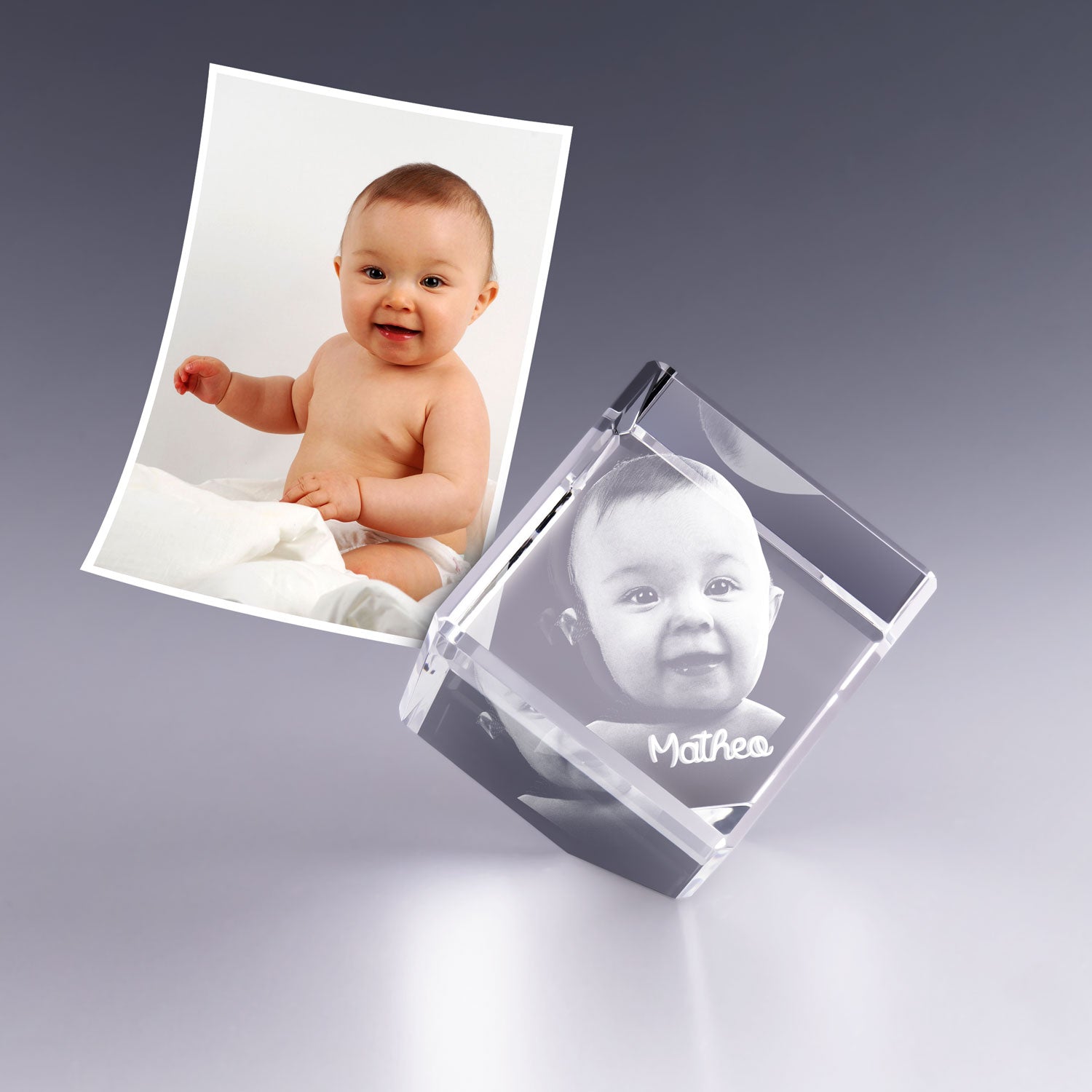 Gravure 3D dans un cube en verre pan coupé de 4 cm représentant un bébé souriant. Cadeau personnalisé en verre idéal pour une naissance.