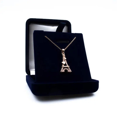 Pendentif Tour Eiffel Cœur en métal doré rose orné de cristaux brillants, présenté dans un écrin bleu nuit personnalisable.