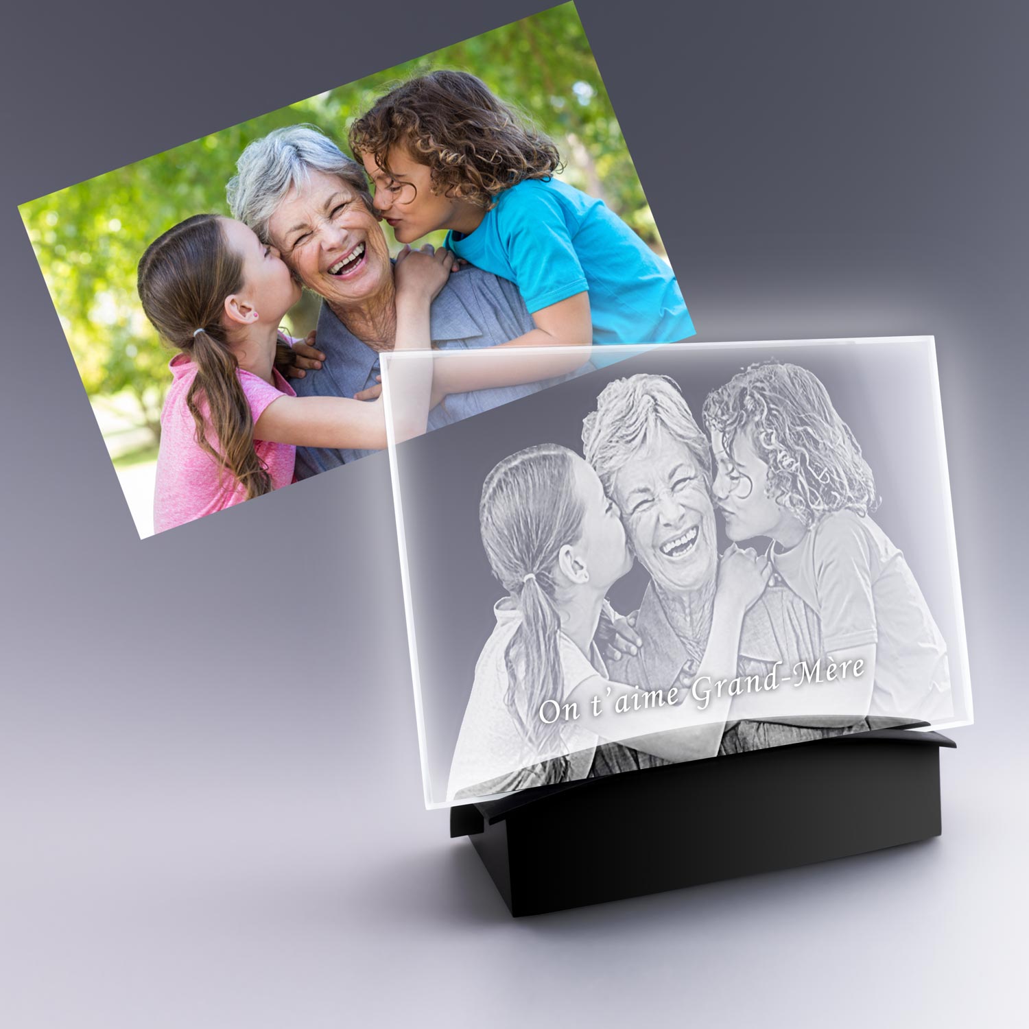 Grande plaque photo horizontale en verre gravé 2D avec socle lumineux, montrant une grand-mère entourée de ses deux petites-filles souriantes avec l’inscription “On t’aime Grand-Mère”.