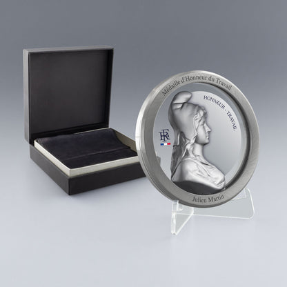 Médaille du travail argentée personnalisée pour 20 ans d’engagement professionnel. Gravure nette et durable, coffret et support inclus.
