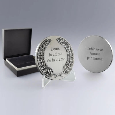 Médaille personnalisable en métal argent avec gravure sur les deux faces. Livrée dans un bel écrin noir avec chevalet pour exposition.