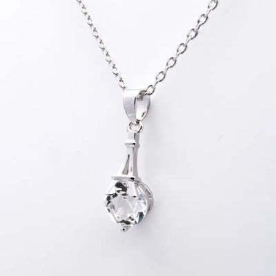Zoom sur pendentif argenté avec cristal Swarovski® serti à la base d’une Tour Eiffel stylisée. Idéal pour un cadeau symbolique et élégant.