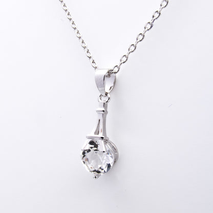 Zoom sur pendentif argenté avec cristal Swarovski® serti à la base d’une Tour Eiffel stylisée. Idéal pour un cadeau symbolique et élégant.