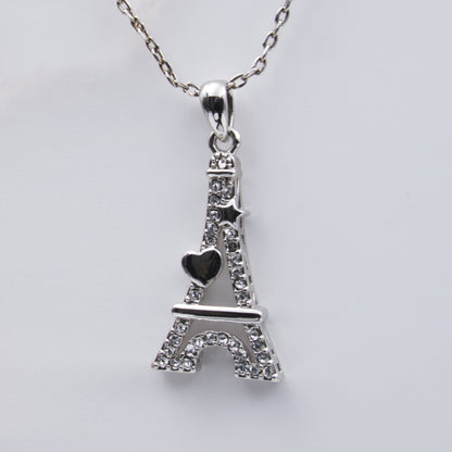 Détail du pendentif Tour Eiffel Cœur en métal argenté, incrusté de strass étincelants et orné d’un cœur noir.