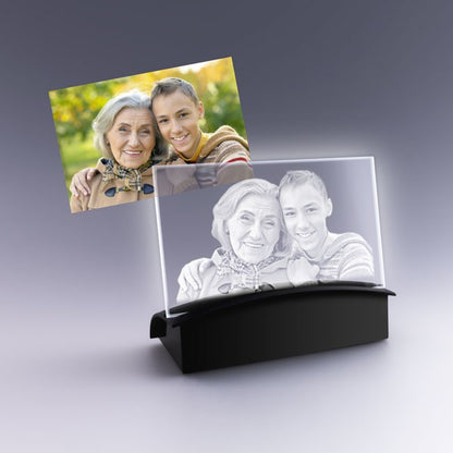 Cadeau photo unique avec gravure 2D d’une grand-mère et son petit-fils dans une plaque horizontale en verre posée sur socle lumineux pour mise en valeur.