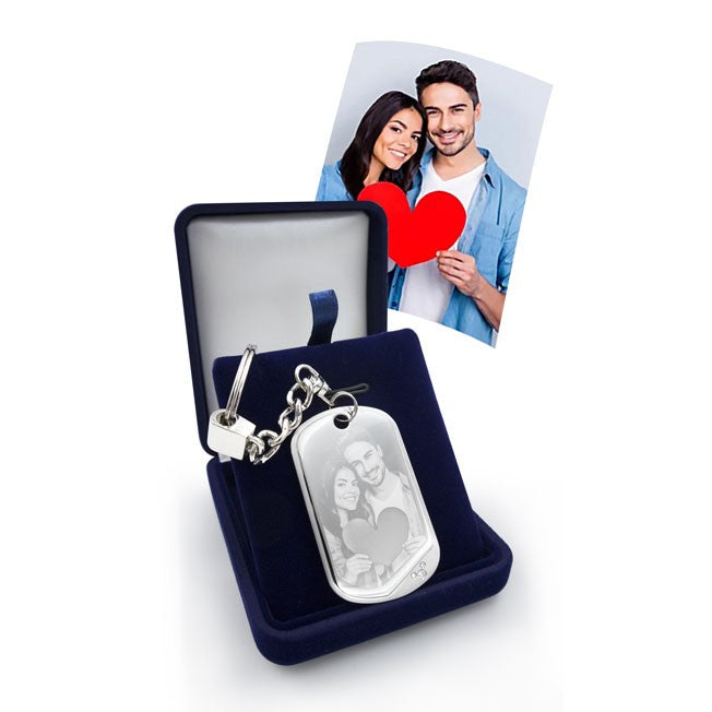 Porte-clés gravé avec la photo d’un couple tenant un cœur rouge, livré dans un écrin. Cadeau personnalisé idéal pour la Saint-Valentin ou un anniversaire de couple.