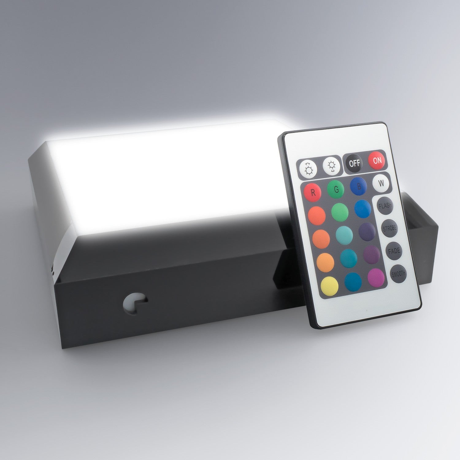 Le socle lumineux carré est présenté avec sa télécommande multicolore, permettant de choisir l’éclairage parfait pour sublimer un bloc en verre personnalisé.