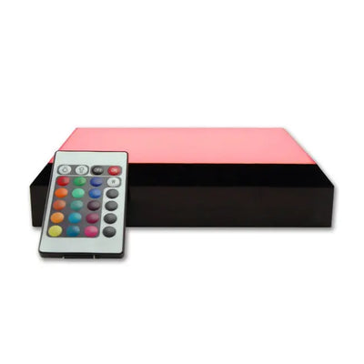Socle lumineux interactif avec éclairage rouge et télécommande multifonction. Il est conçu pour valoriser les blocs photo en verre dans une atmosphère chaleureuse.
