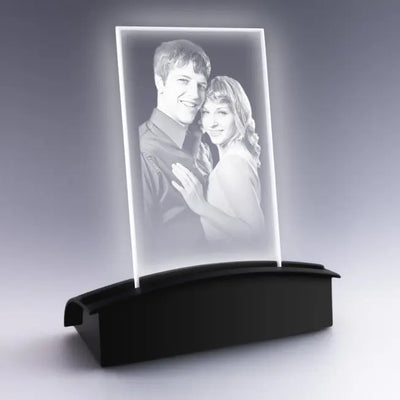 Portrait de couple gravé dans une plaque en verre, posé sur un socle tunnel à LED blanc offrant une lumière pure et raffinée pour sublimer la photo.