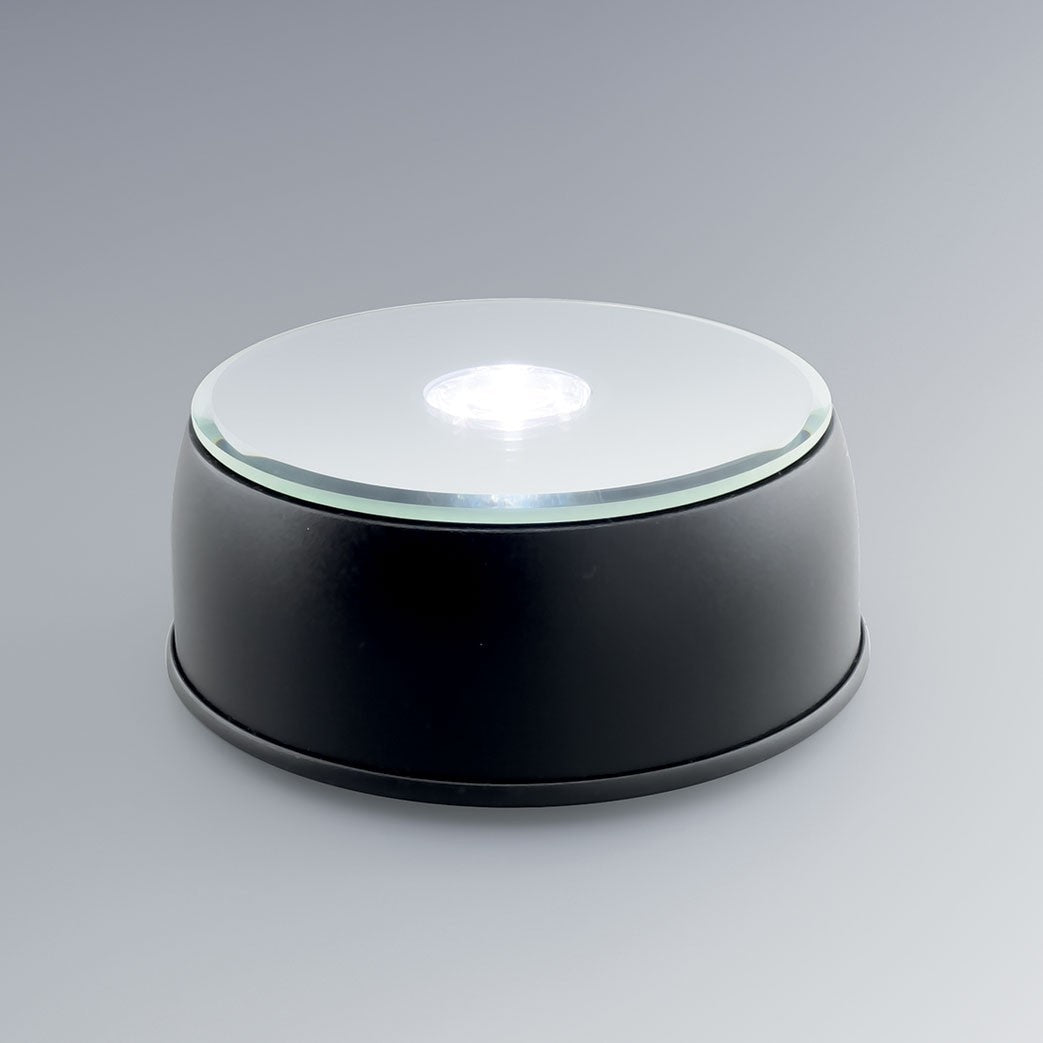 Socle lumineux rotatif à LED blanc et couleurs pour blocs en verre gravés 3D. Parfait pour exposer vos gravures personnalisées avec un éclairage dynamique.