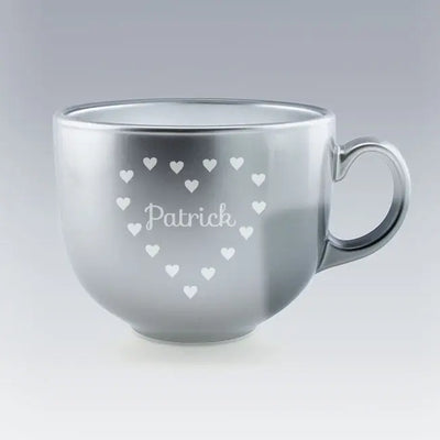 Tasse Jumbo argentée avec le prénom "Patrick" gravé au centre d’un motif en forme de cœur composé de petits cœurs blancs, sur fond clair dégradé.