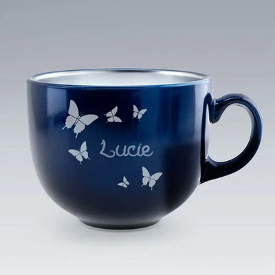 Tasse Jumbo bleu profond avec papillons et prénom Lucie gravés. Design élégant et généreux, parfait pour les amateurs de grandes tasses.